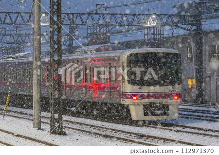 Limited express train running in the snow, Keio Line, Snowy day, Takahatafudo Station 112971370