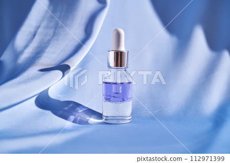 Two-component facial serum on a blue silk background. Two-component facial serum on a blue silk background. 112971399