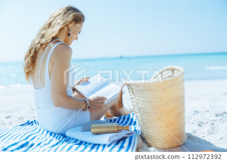 relaxed elegant female on ocean coast with straw bag relaxed elegant female on ocean coast with straw bag 112972392