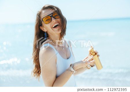happy modern female on ocean shore with spf happy modern female on ocean shore with spf 112972395