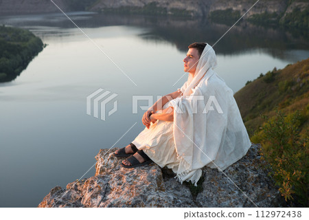 Young man sitting on the rock 112972438