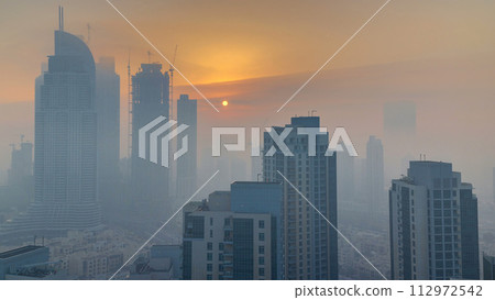 Foggy morning sunrise in downtown of Dubai timelapse. Foggy morning sunrise in downtown of Dubai timelapse. 112972542