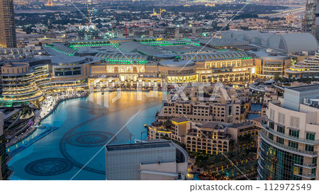 Night aerial view Dancing fountains downtown and in a man-made lake timelapse in Dubai, UAE. 112972549