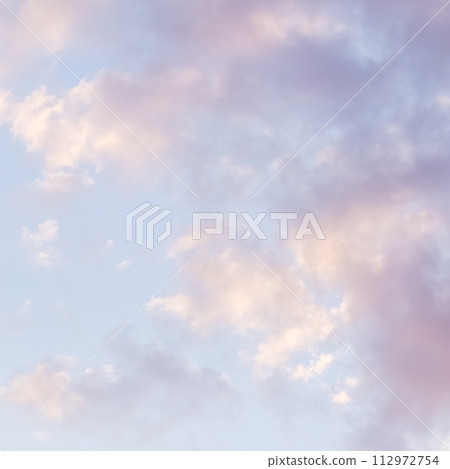 Blue sky background with pale pink clouds at sunset 112972754