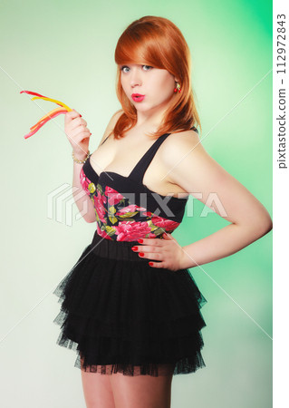 Redhair girl holding sweet food jelly candy on green. 112972843