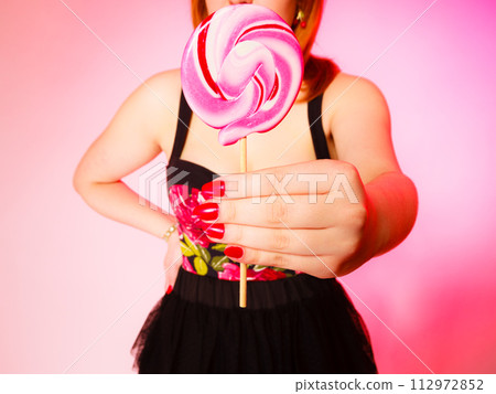 Woman with sweet candy lollipop in hand. 112972852