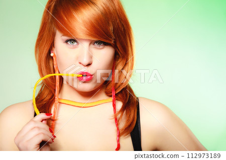 Redhair girl holding sweet food jelly candy on green. 112973189
