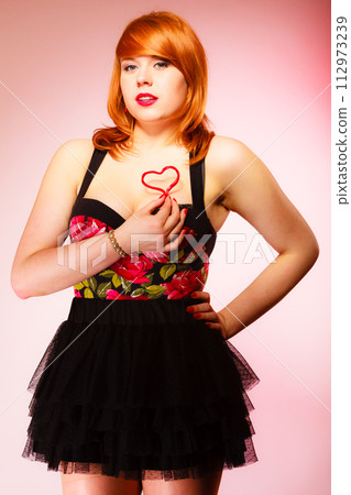 Gorgeous young woman holding candy heart. Gorgeous young woman holding candy heart. 112973239