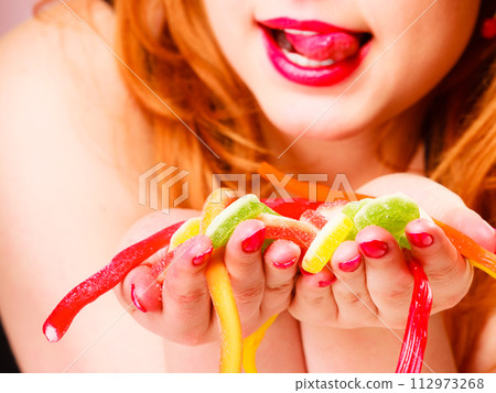 Multi colored jelly sweets in woman hands. 112973268