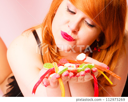 Multi colored jelly sweets in woman hands. 112973269