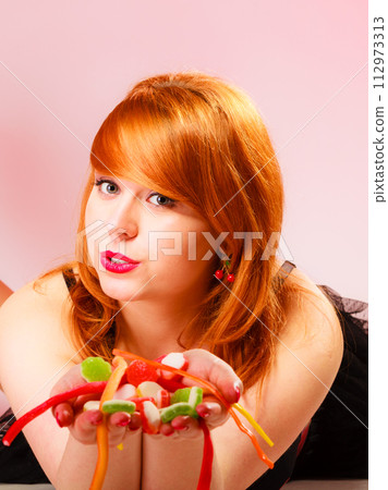 Multi colored jelly sweets in woman hands. 112973313