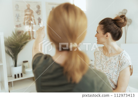 Seen from behind female therapist in massage cabinet 112973413