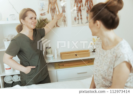 happy female medical massage therapist in massage cabinet 112973414