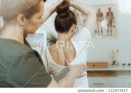 concerned female therapist in massage cabinet doing checkup 112973417