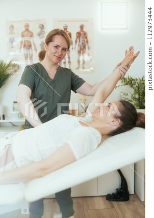 happy female massage therapist in massage cabinet doing checkup 112973444