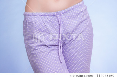 Pyjamas. Female legs wearing violet pajama pants 112973469