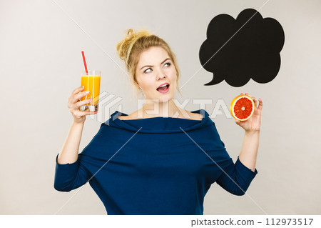 Happy woman holding fresh orange juice 112973517