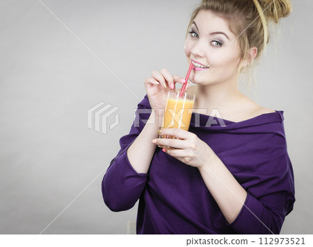 Happy woman holding fresh orange juice 112973521