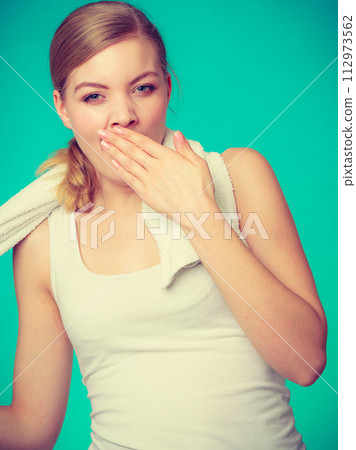 Bored sleepy woman yawning while holding towel 112973562