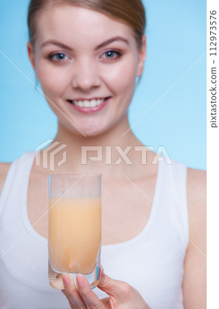 Woman holding glass with water and effervescent tablet Woman holding glass with water and effervescent tablet 112973576