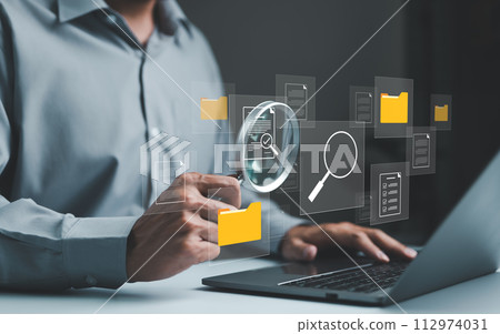 Businessman using computer to manage document files in folders. folder file storage on cloud. share database online, software for archiving and company data. DMS Document management system concept. 112974031
