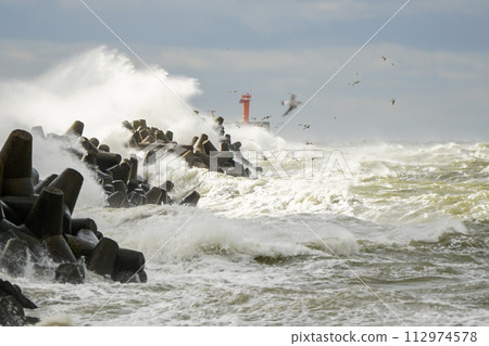 Big wave breaking on breakwater, stormy sea, crashing waves, wave splashing, hurricane season Big wave breaking on breakwater, stormy sea, crashing waves, wave splashing, hurricane season 112974578