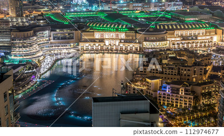 Night aerial view Dancing fountains downtown and in a man-made lake timelapse in Dubai, UAE. 112974677