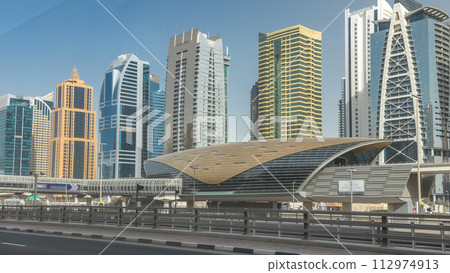View of Jumeirah lakes towers skyscrapers and metro sration timelapse with traffic on sheikh zayed road. 112974913