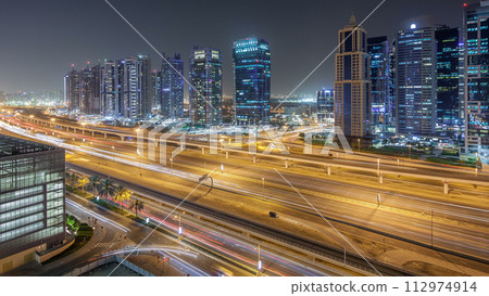 Aerial view of Jumeirah lakes towers skyscrapers night timelapse with traffic on sheikh zayed road. Aerial view of Jumeirah lakes towers skyscrapers night timelapse with traffic on sheikh zayed road. 112974914