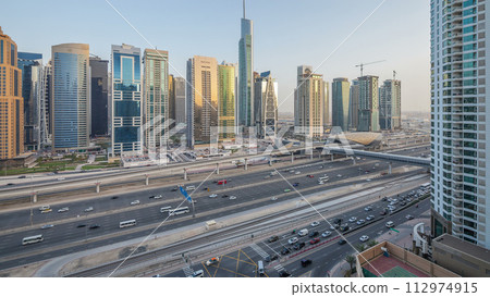 Aerial view of Jumeirah lakes towers skyscrapers day to night timelapse with traffic on sheikh zayed road. 112974915