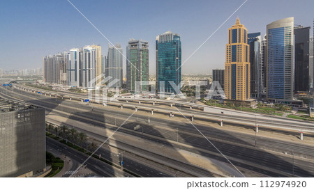 Aerial view of Jumeirah lakes towers skyscrapers timelapse with traffic on sheikh zayed road. 112974920