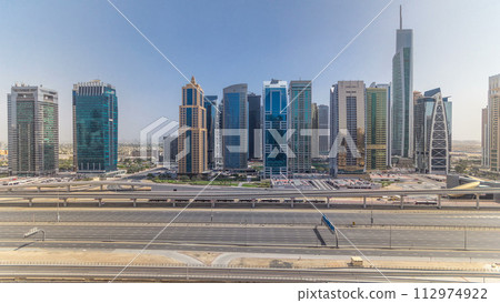 Aerial view of Jumeirah lakes towers skyscrapers all day timelapse with traffic on sheikh zayed road. Aerial view of Jumeirah lakes towers skyscrapers all day timelapse with traffic on sheikh zayed road. 112974922