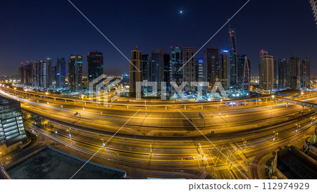 Aerial view of Jumeirah lakes towers skyscrapers night to day timelapse with traffic on sheikh zayed road. 112974929