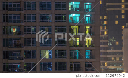 Windows of the multi-storey building of glass and steel lighting inside and moving people within timelapse Windows of the multi-storey building of glass and steel lighting inside and moving people within timelapse 112974942