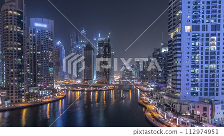 Water canal on Dubai Marina skyline at night timelapse. 112974951