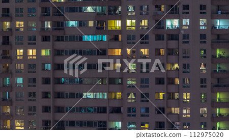 Glowing windows of skyscrapers at evening timelapse Glowing windows of skyscrapers at evening timelapse 112975020