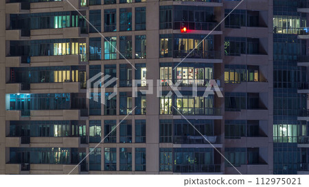 Glowing windows of skyscrapers at evening timelapse 112975021