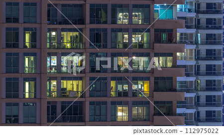 Glowing windows of skyscrapers at evening timelapse Glowing windows of skyscrapers at evening timelapse 112975022