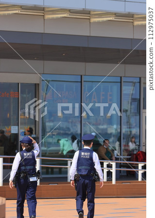 Police officers patrolling the airport Back view Security Metropolitan Police Department 112975037