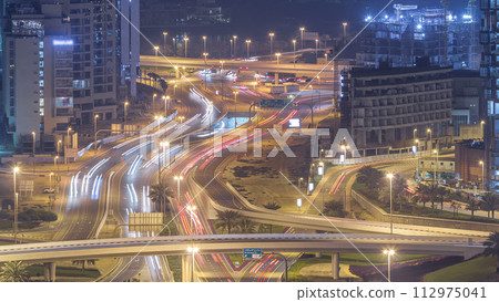 Aerial view of a road intersection in a big city night timelapse. Aerial view of a road intersection in a big city night timelapse. 112975041
