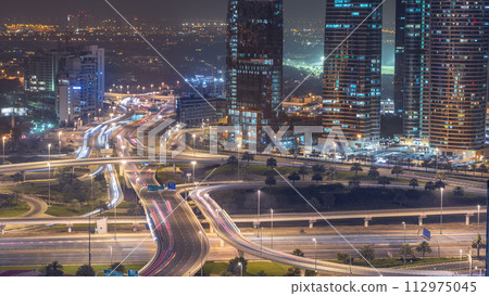 Aerial view of a road intersection in a big city night timelapse. Aerial view of a road intersection in a big city night timelapse. 112975045