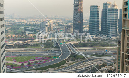 Aerial view of a road intersection in a big city day to night timelapse. Aerial view of a road intersection in a big city day to night timelapse. 112975047