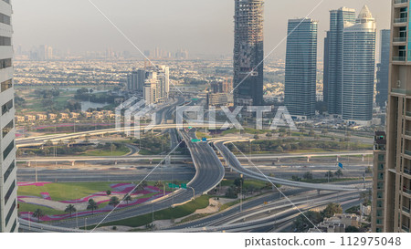 Aerial view of a road intersection in a big city at sunset timelapse. Aerial view of a road intersection in a big city at sunset timelapse. 112975048