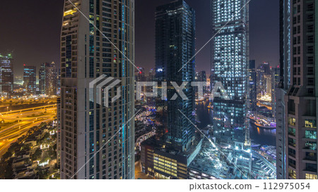 Water canal on Dubai Marina skyline at night timelapse. 112975054