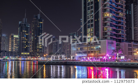 Dubai marina bay with yachts an boats night timelapse 112975073