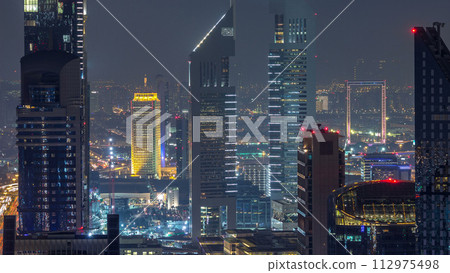 Commercial business district in a summer night timelapse. Dubai, UAE. 112975498