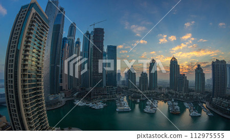 View of modern skyscrapers shining in sunrise lights timelapse in Dubai Marina in Dubai, UAE. 112975555