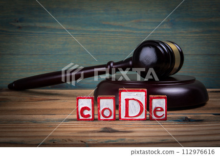 CODE. Red alphabet letters and judge's gavel on wooden background. Laws and justice concept CODE. Red alphabet letters and judge's gavel on wooden background. Laws and justice concept 112976616