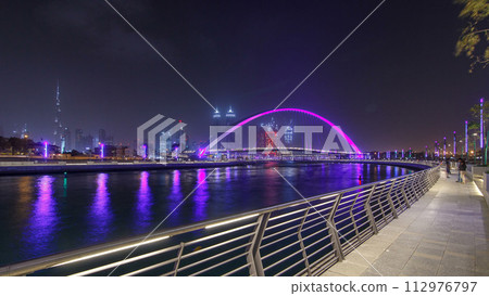 Pedestrian Bridge over the Dubai Water Canal night timelapse hyperlapse, United Arab Emirates 112976797
