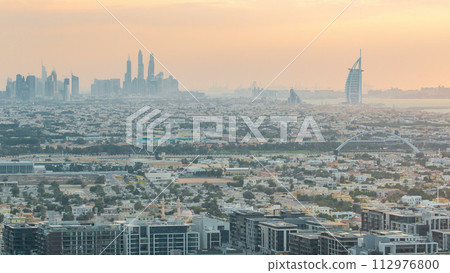 Dubai skyline with Dubai Marina skyscrapers and coastline at sunset timelapse with seven star luxury hotel in Dubai, UAE. 112976800